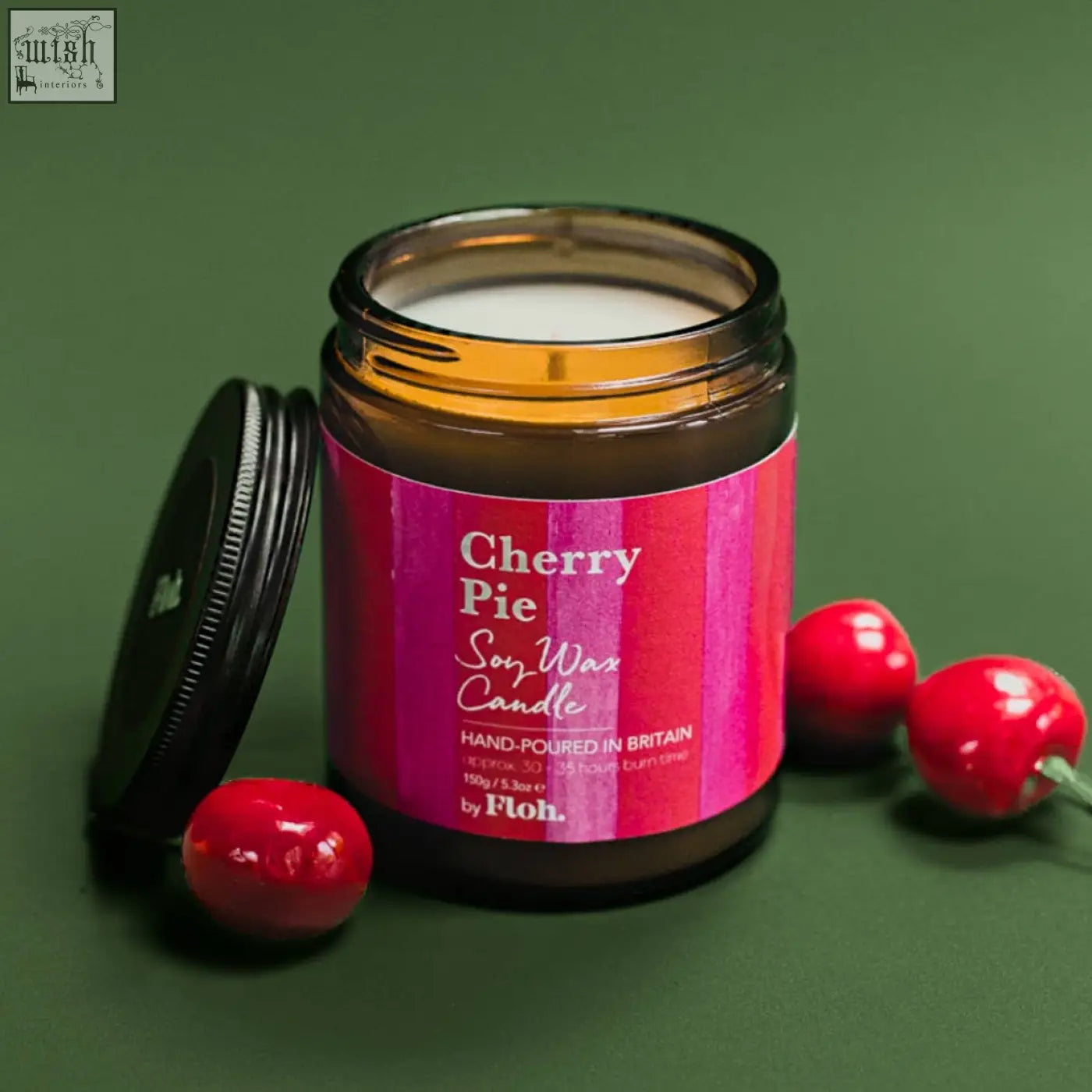 A vibrant pink-labeled cherry pie apothecary soy wax candle in amber glass jar hand-poured in britain by ploh
