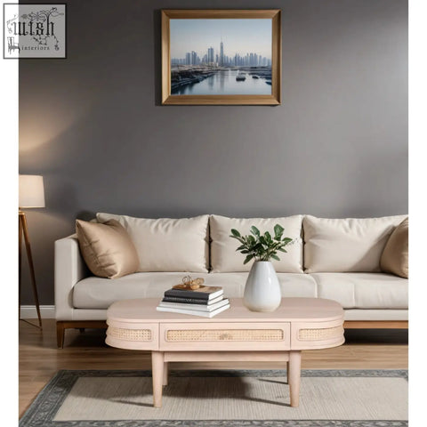 Beige oval chester coffee table with woven cane accents and light wood legs featuring natural materials