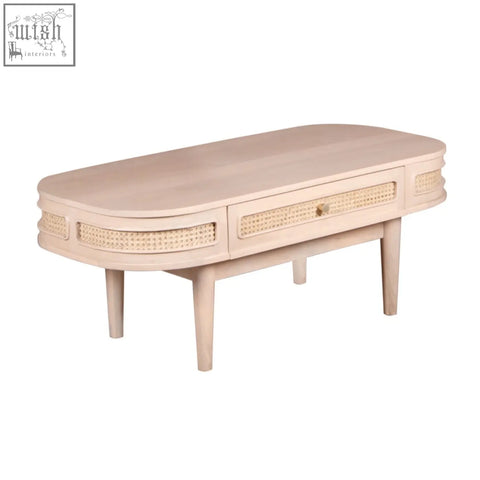 Beige oval chester coffee table with woven cane accents natural materials and a single drawer for storage