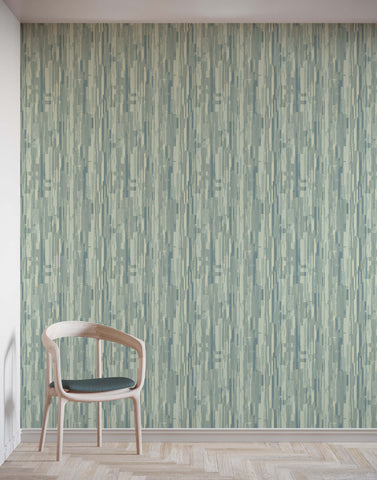 A chester minimalist wooden chair with a dark green cushion against textured sage green wallpaper