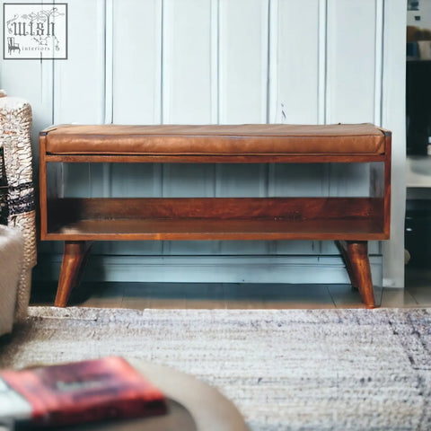 Chestnut bench with brown leather seat pad wooden base lower shelf and tapered legs for stylish seating