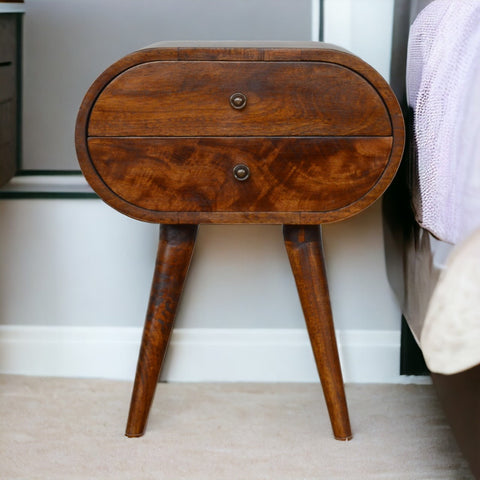 Chestnut circular bedside table with warm wood finish smooth oval top and two drawers with round metal knobs