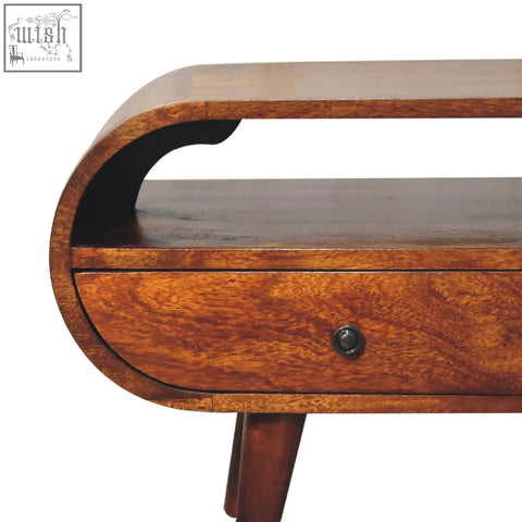 Curved walnut wood side table with a drawer and tapered legs in a chestnut circular tv stand made from solid mango wood