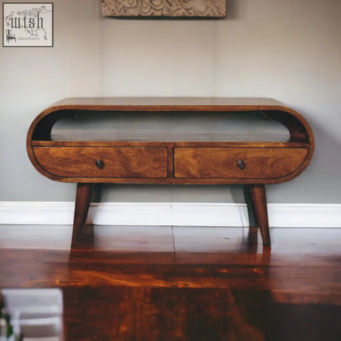 A sleek chestnut circular tv stand made of solid mango wood with two drawers and tapered legs