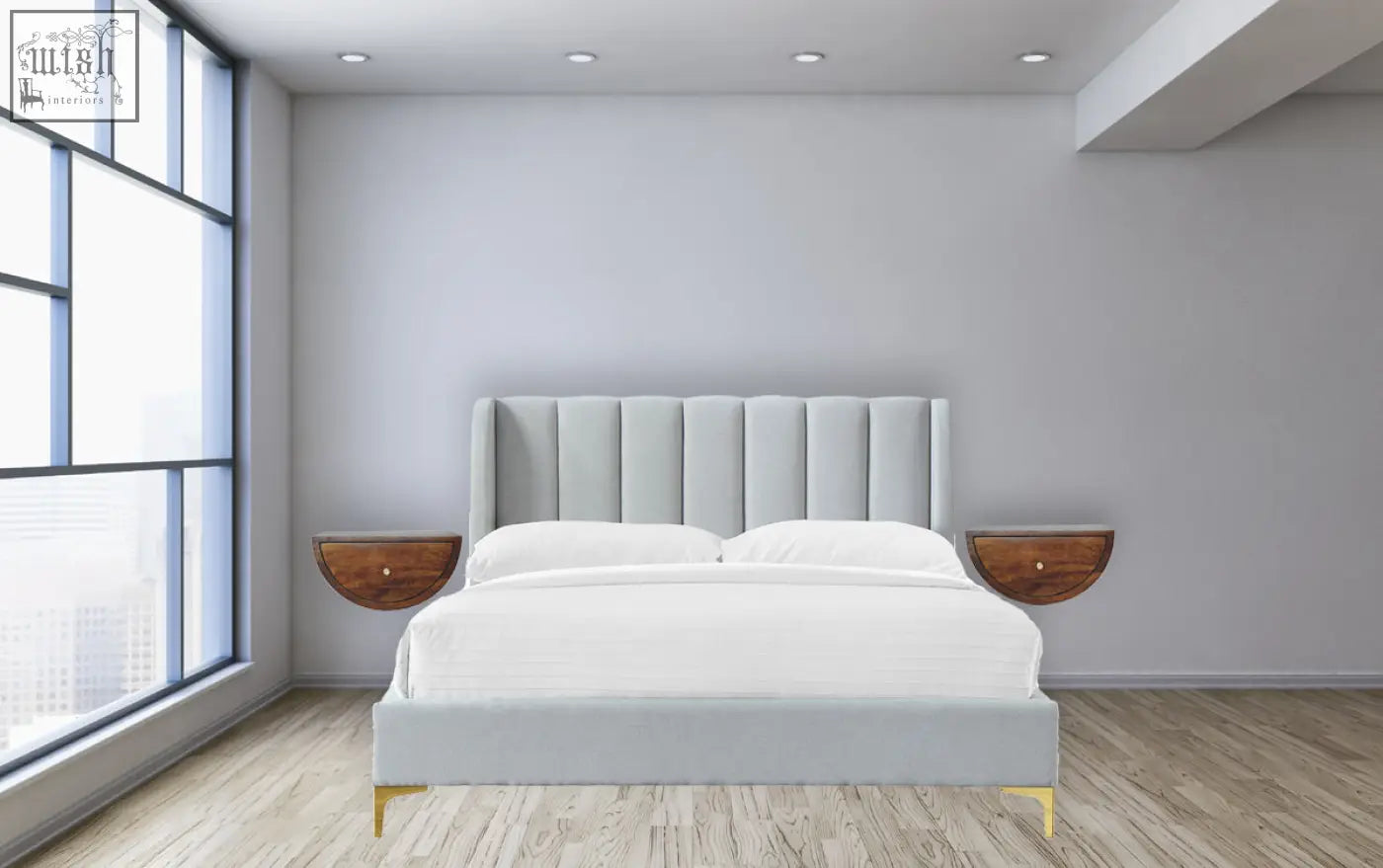 Light gray upholstered bed with tufted headboard and gold-tone legs next to chestnut crescent floating bedside table wall-mounted