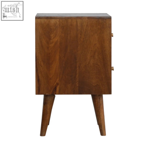 A rustic chestnut cube carved bedside table with warm brown drawer fronts and tapered legs for cozy storage