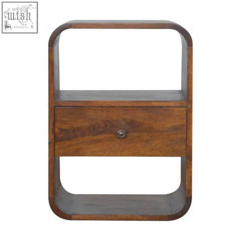 A chestnut curved edge bedside table made of solid mango wood with a single drawer and two open shelves in warm brown