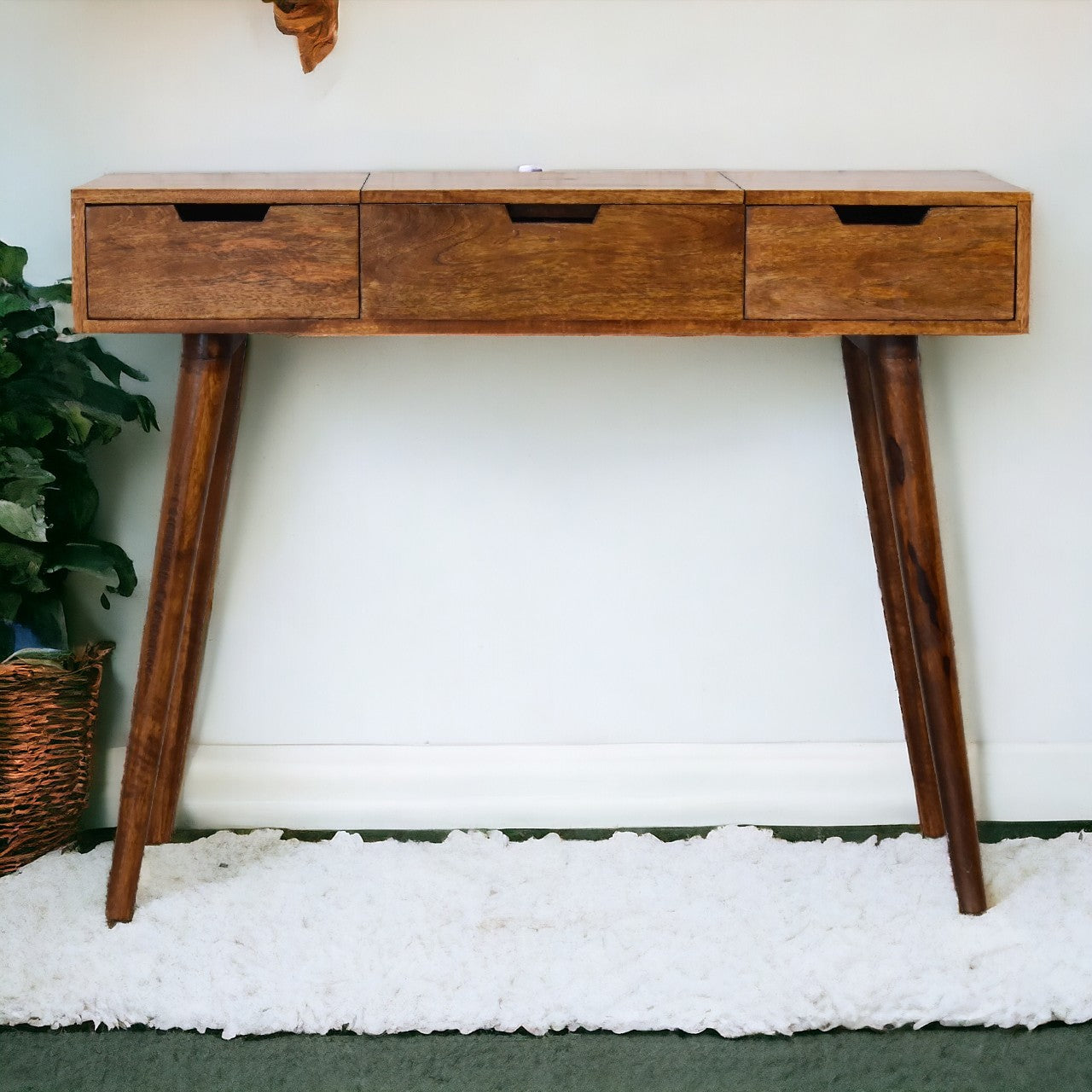 A sleek chestnut foldable mirror table in medium brown hand-painted mango wood with three drawers and tapered legs