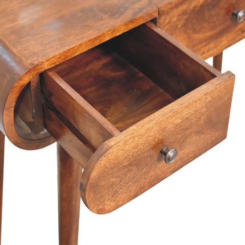 A warm medium-toned wooden chestnut mirror console table with a curved front and open drawer with round knob