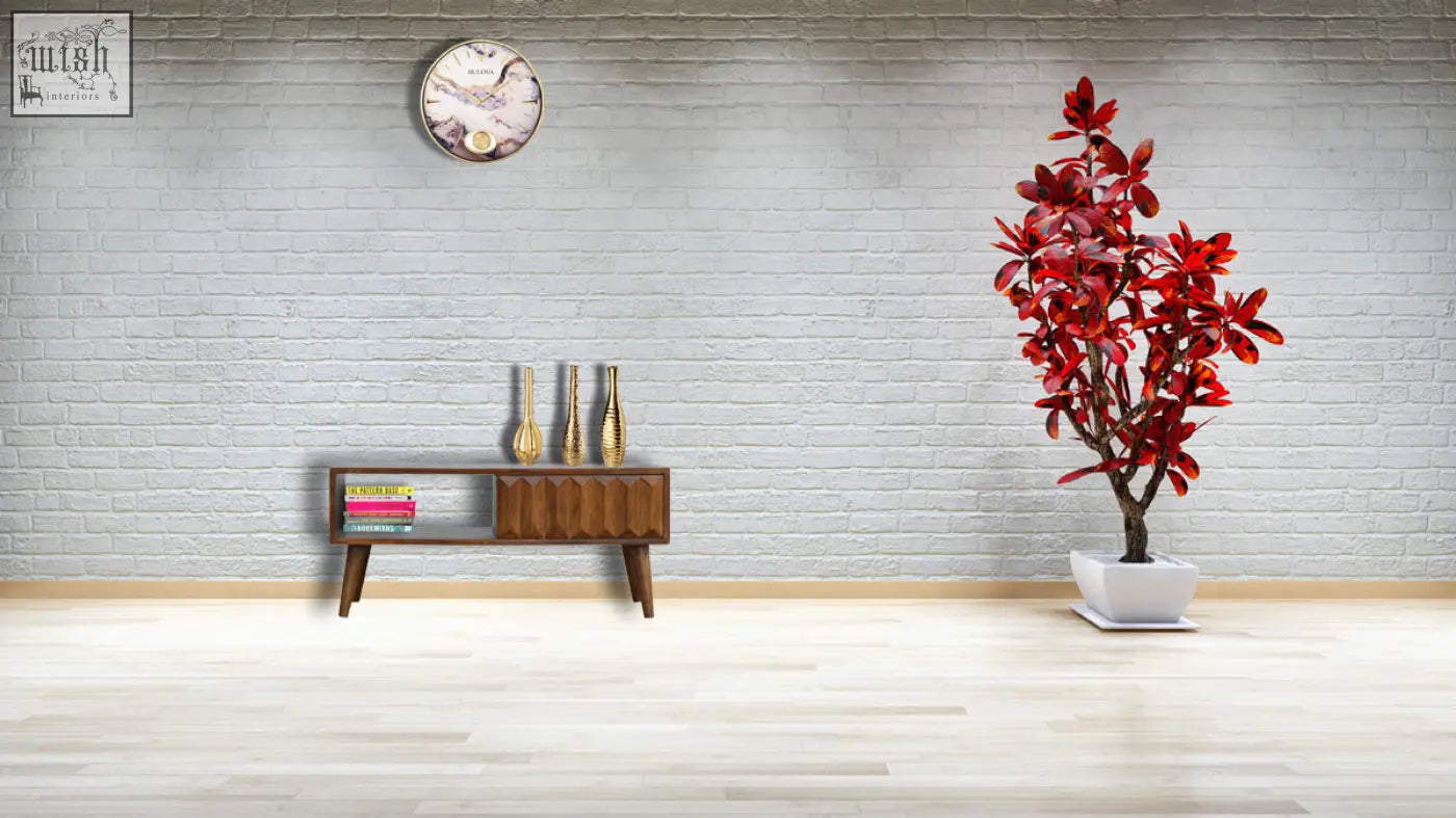 A vibrant red artificial tree in a white ceramic pot next to a chestnut prism sliding chest of drawers in solid mango wood