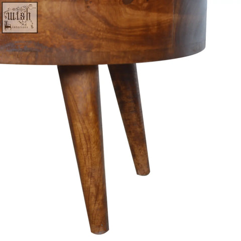 Chestnut rounded coffee table with a warm medium brown finish made of solid mango wood featuring visible grain patterns