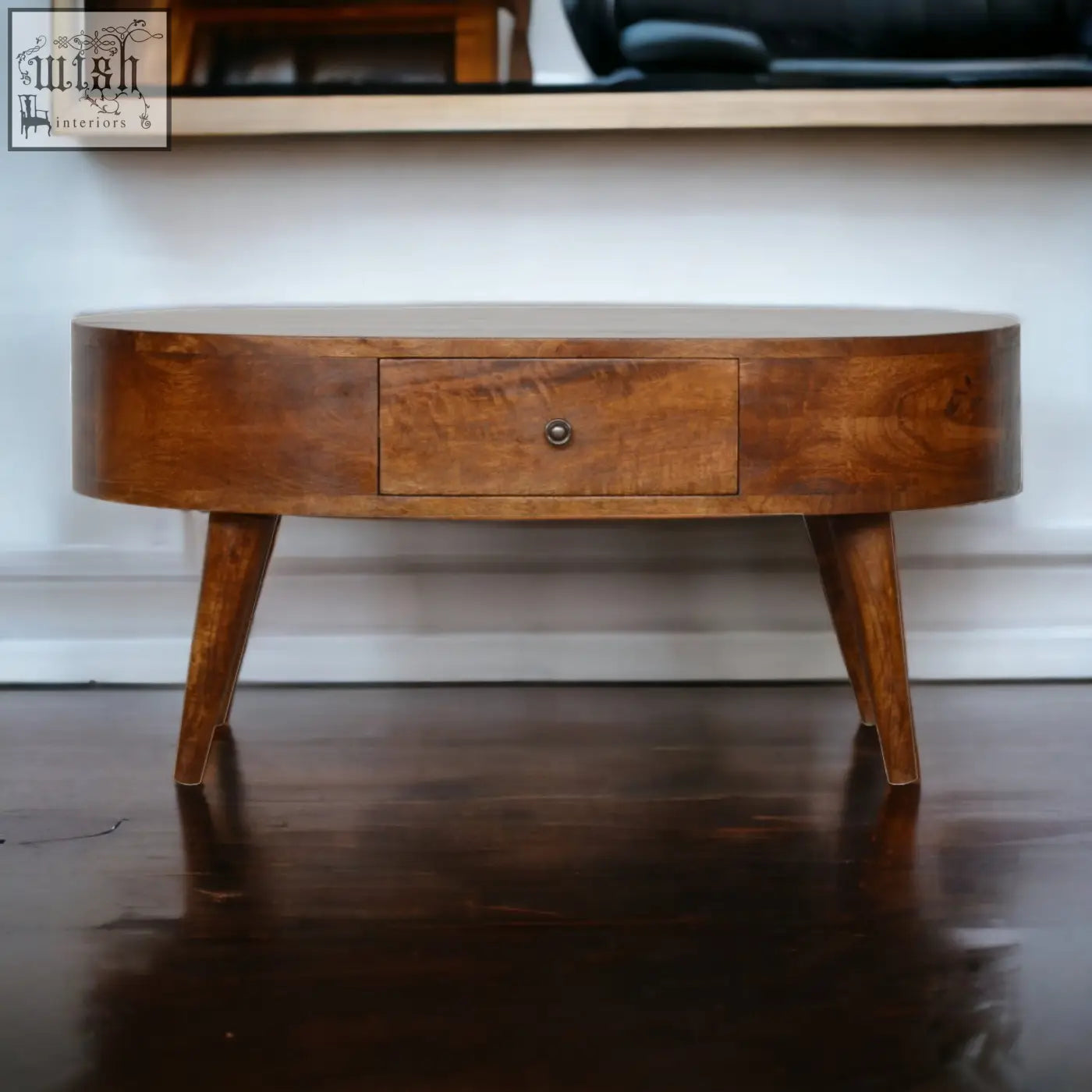 Chestnut rounded coffee table with a warm oval shape, single drawer, tapered legs, and solid mango wood build
