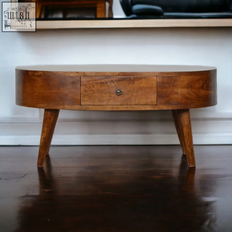 Chestnut rounded coffee table with a warm oval shape, single drawer, tapered legs, and solid mango wood build