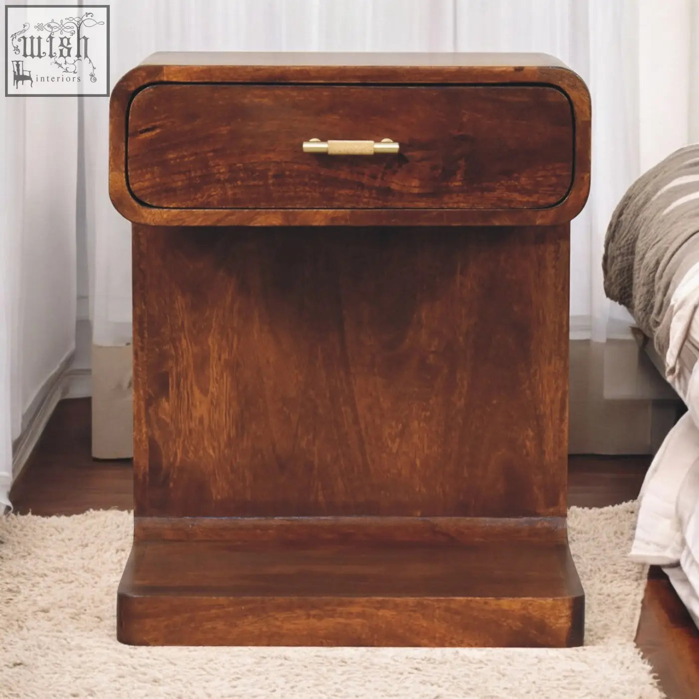 Rich brown mango wood rounded bedside table with single drawer and brass handle for bedside storage
