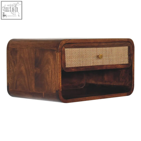 Dark wood wall-mounted bedside table with woven cane drawer front and brass knob made from solid mango wood