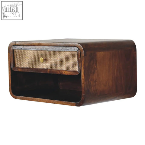 Dark wood wall-mounted bedside table with cane drawer front and brass knob made of solid mango wood