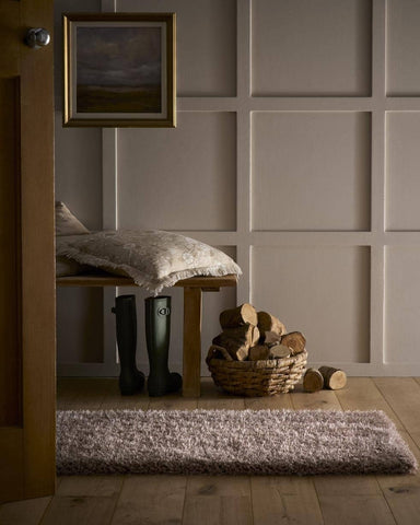 A plush textured gray chicago latte shaggy rug with a soft shaggy surface on a wooden floor