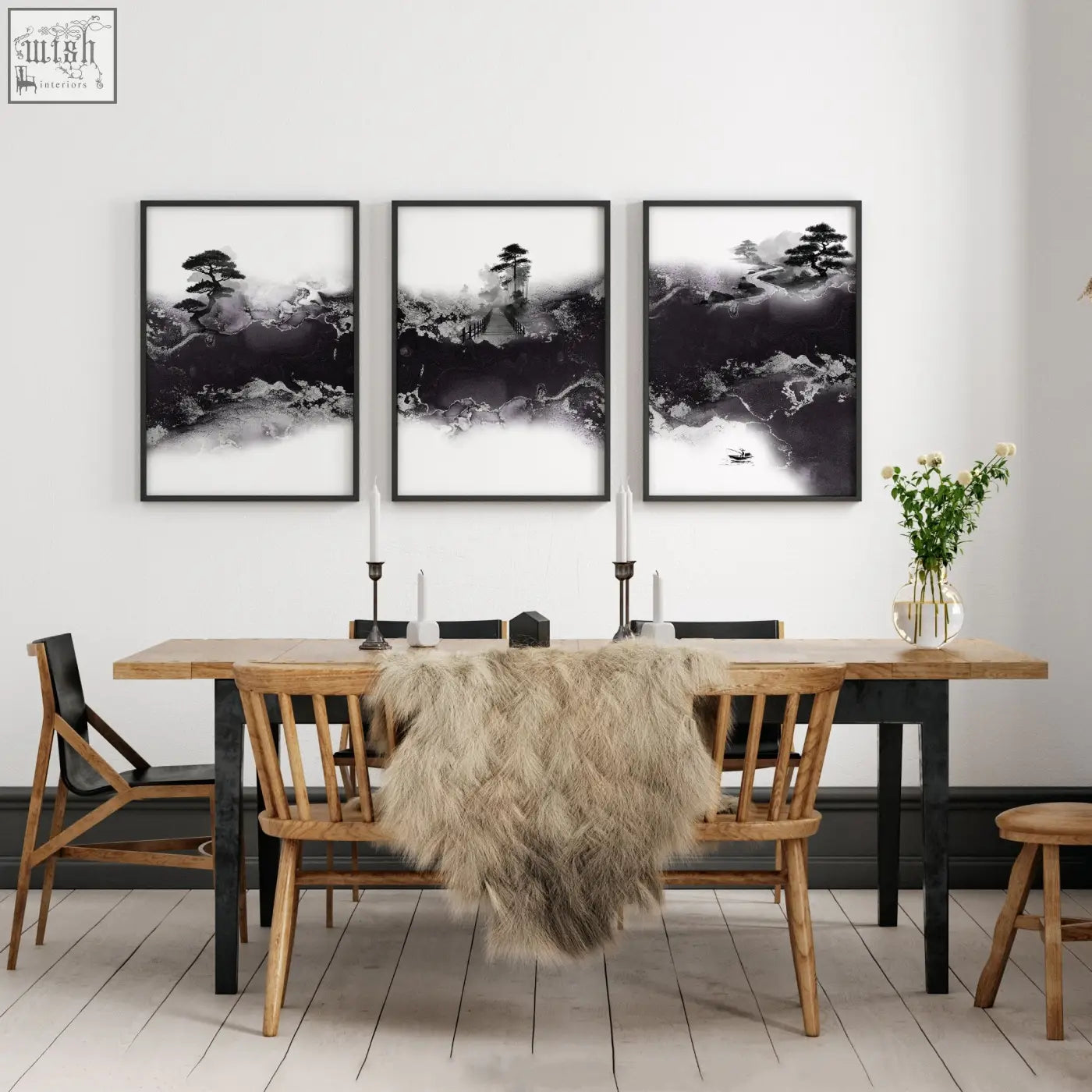 Three black and white chinese artwork prints of bonsai and misty mountains hang above a wooden dining room table