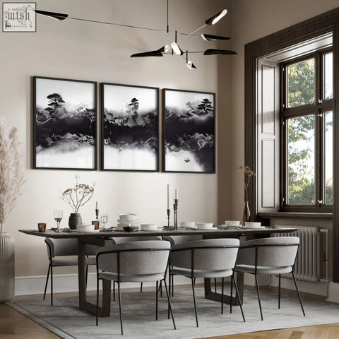 Three framed black and white chinese artwork prints featuring ink landscape of misty mountains hang above dining room table