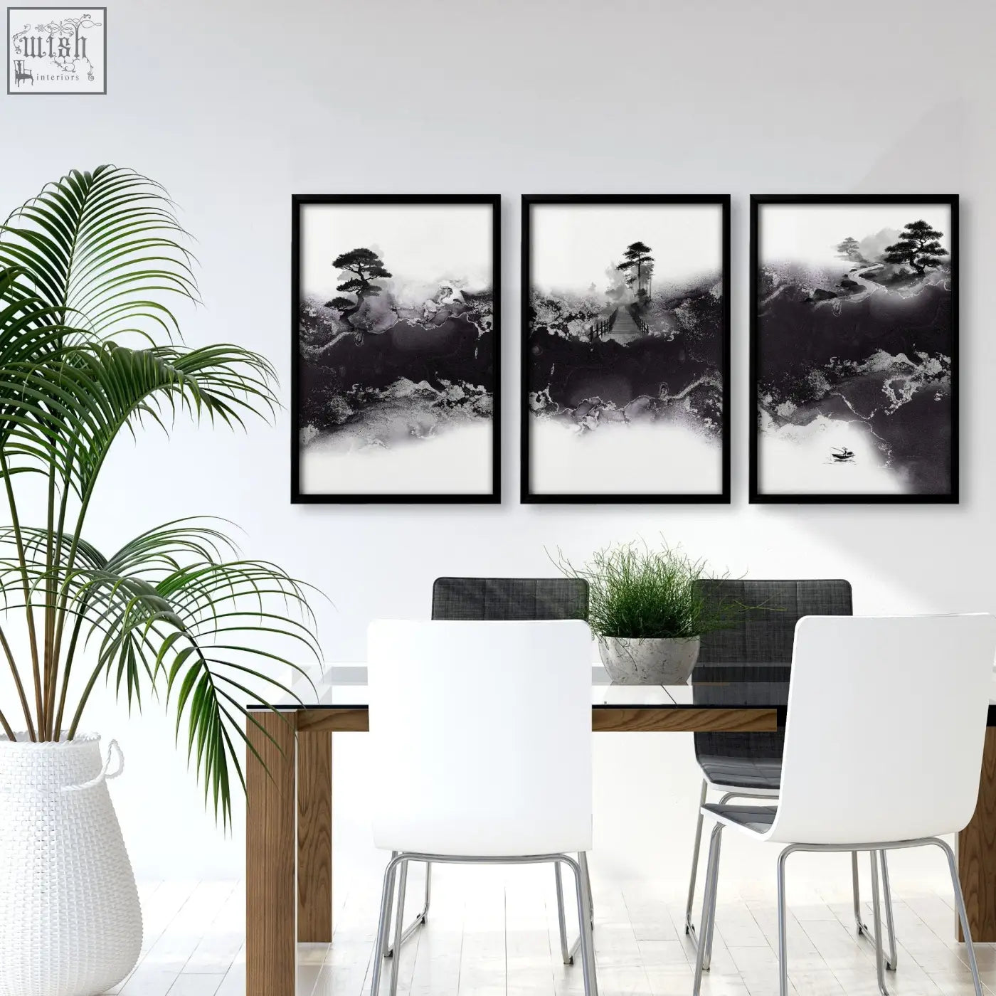 Three black-framed chinese artwork prints of ink wash misty mountains hang above a dining room table