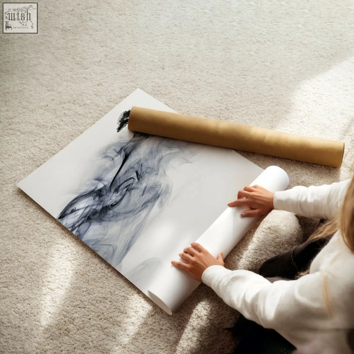 A large abstract ink wash landscape with swirling black and gray ink on white canvas being partially rolled up by hands