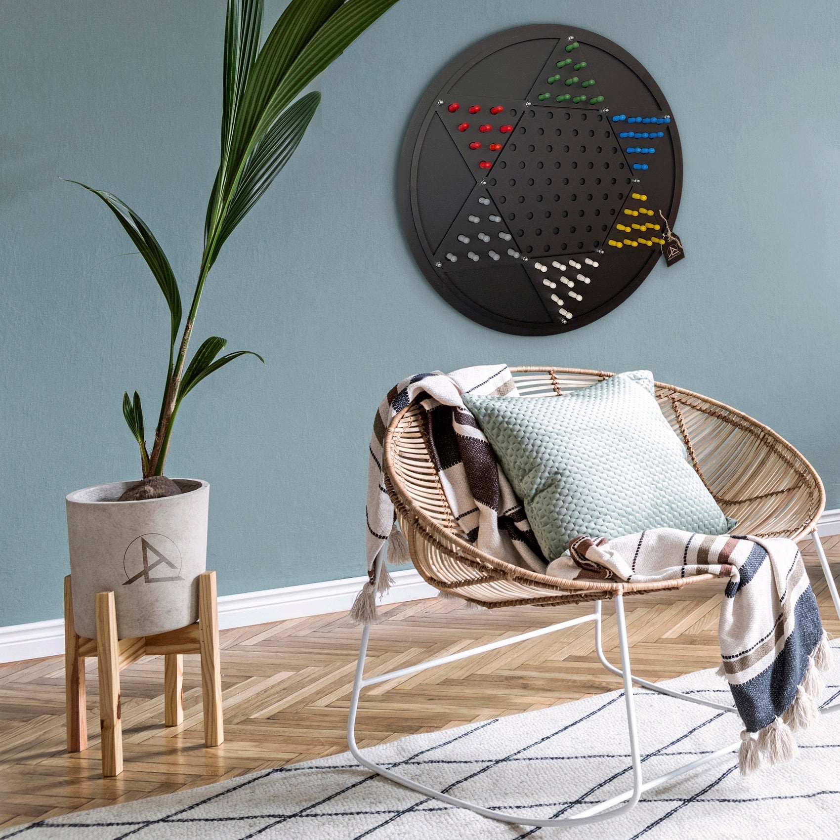 Black circular chinese checkers wall game board with colorful pieces arranged on grid opposite triangle design