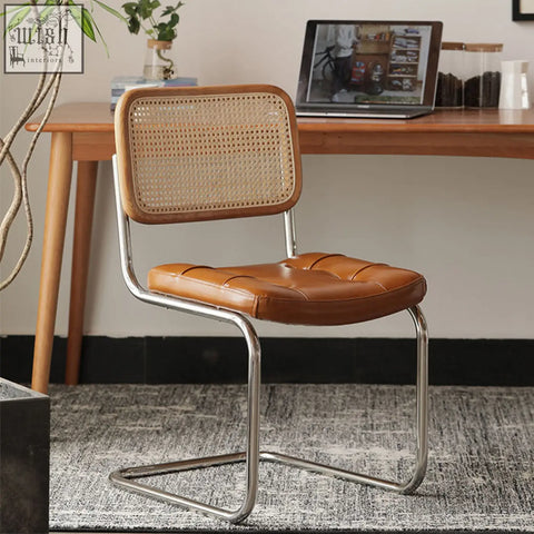 Brown leather chloe rattan dining chair with tufted seat, woven cane backrest, and chrome cantilever frame