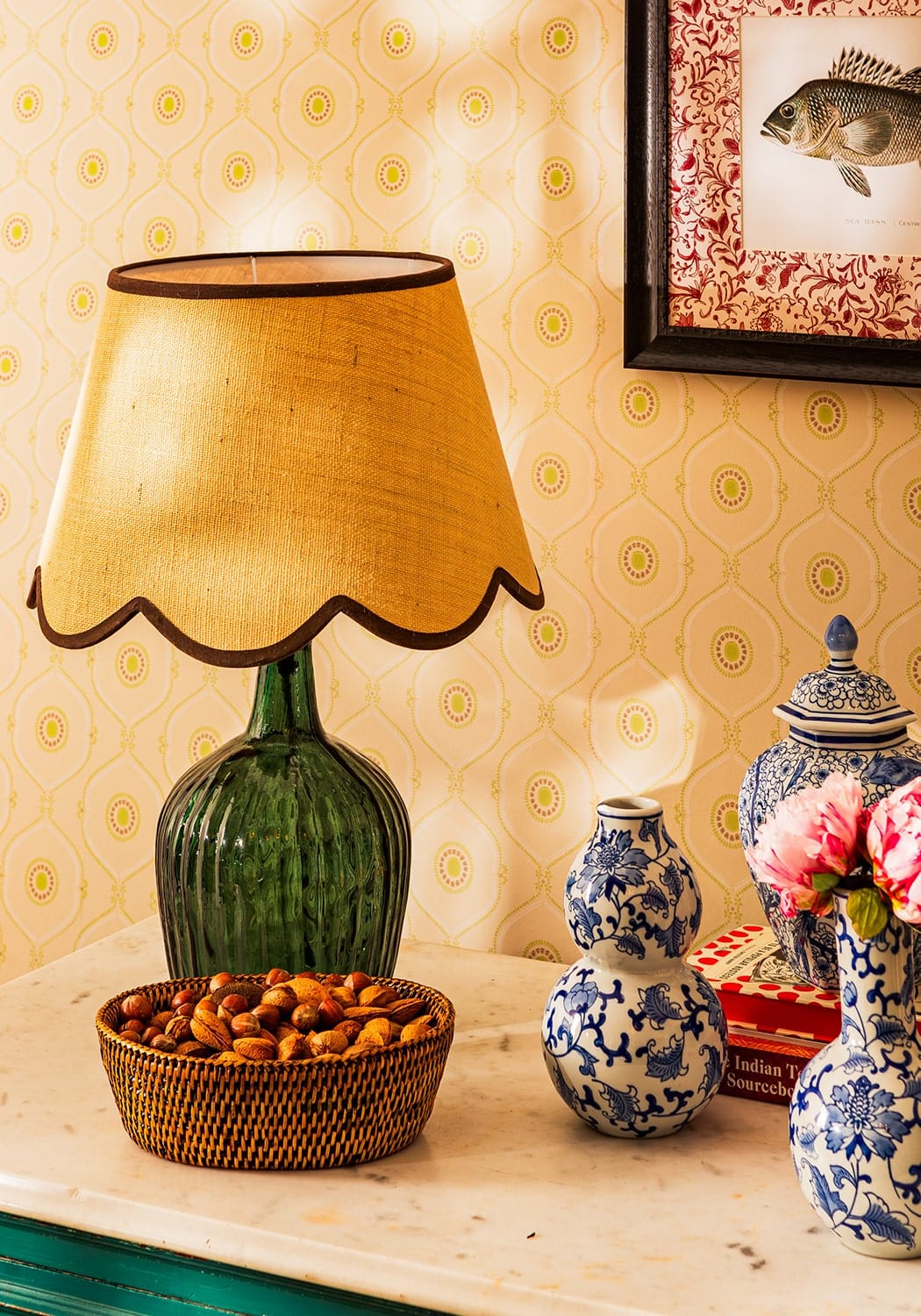 A green ribbed glass table lamp with a brown jute scallop lampshade in golden yellow fabric