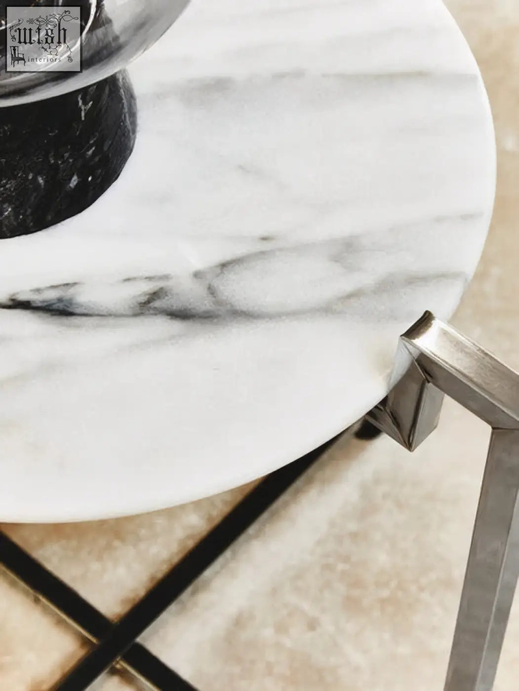 A sleek cibal white marble side table with grey veining and a modern chrome base perfect for any room