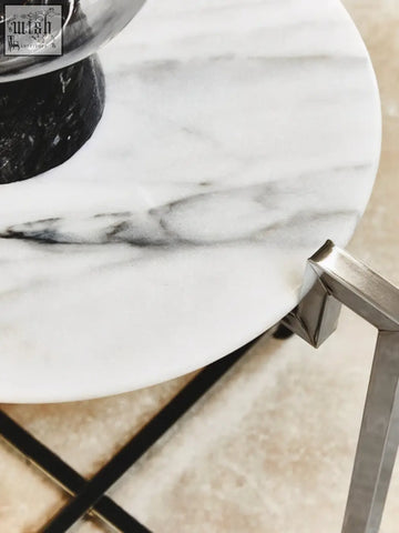 A sleek cibal white marble side table with grey veining and a modern chrome base perfect for any room