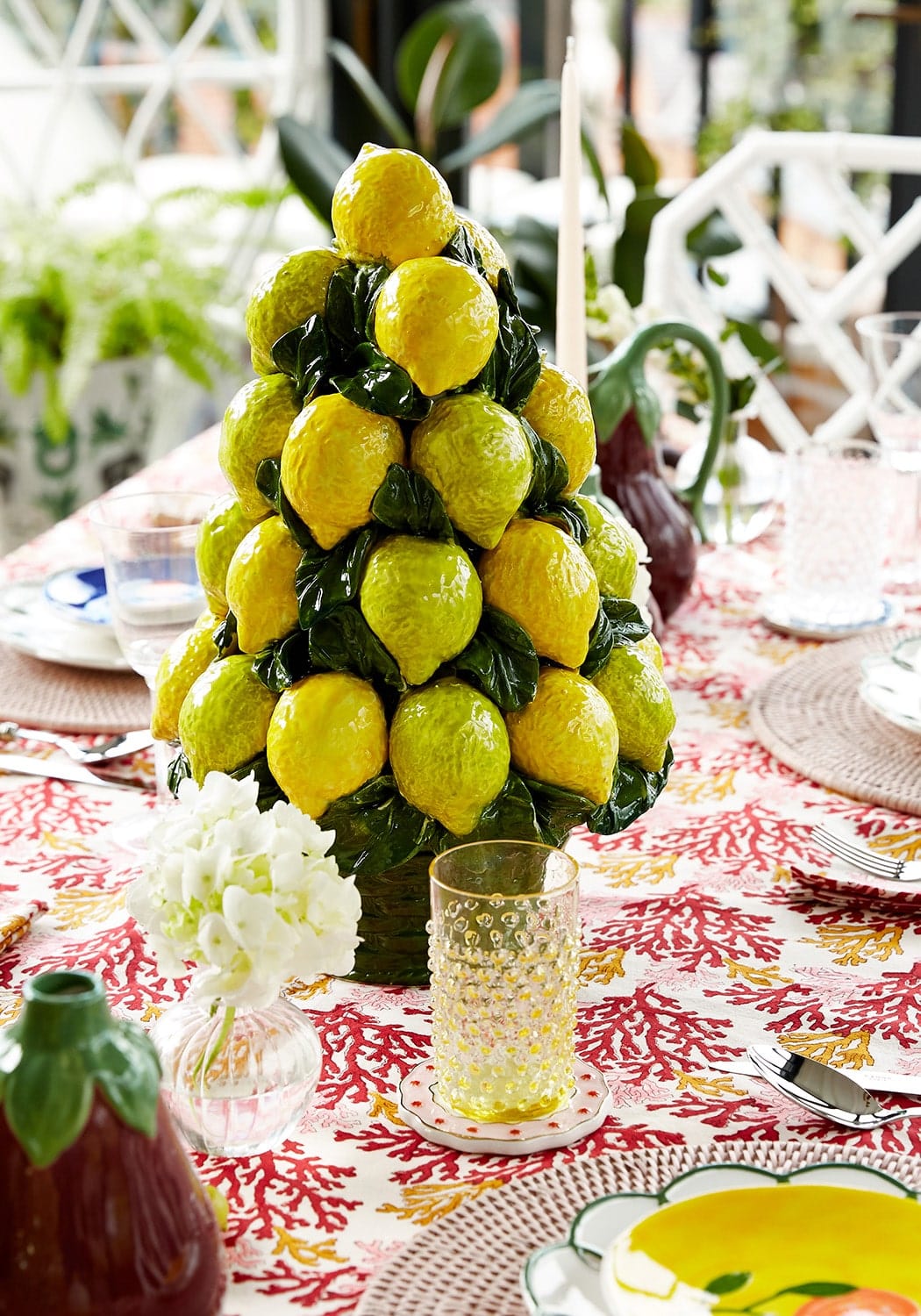 A vibrant yellow ceramic lemon tree centerpiece with glossy green leaves perfect for decorating around dew drop tumblers