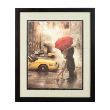 Black-framed wall art of a city framed couple sharing a red umbrella with yellow taxis on a rainy street