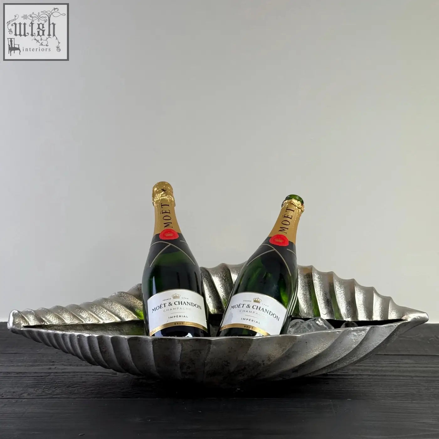 Silver clam shell solid cast ice bucket shaped like a leaf holding two bottles of moët champagnes cooler