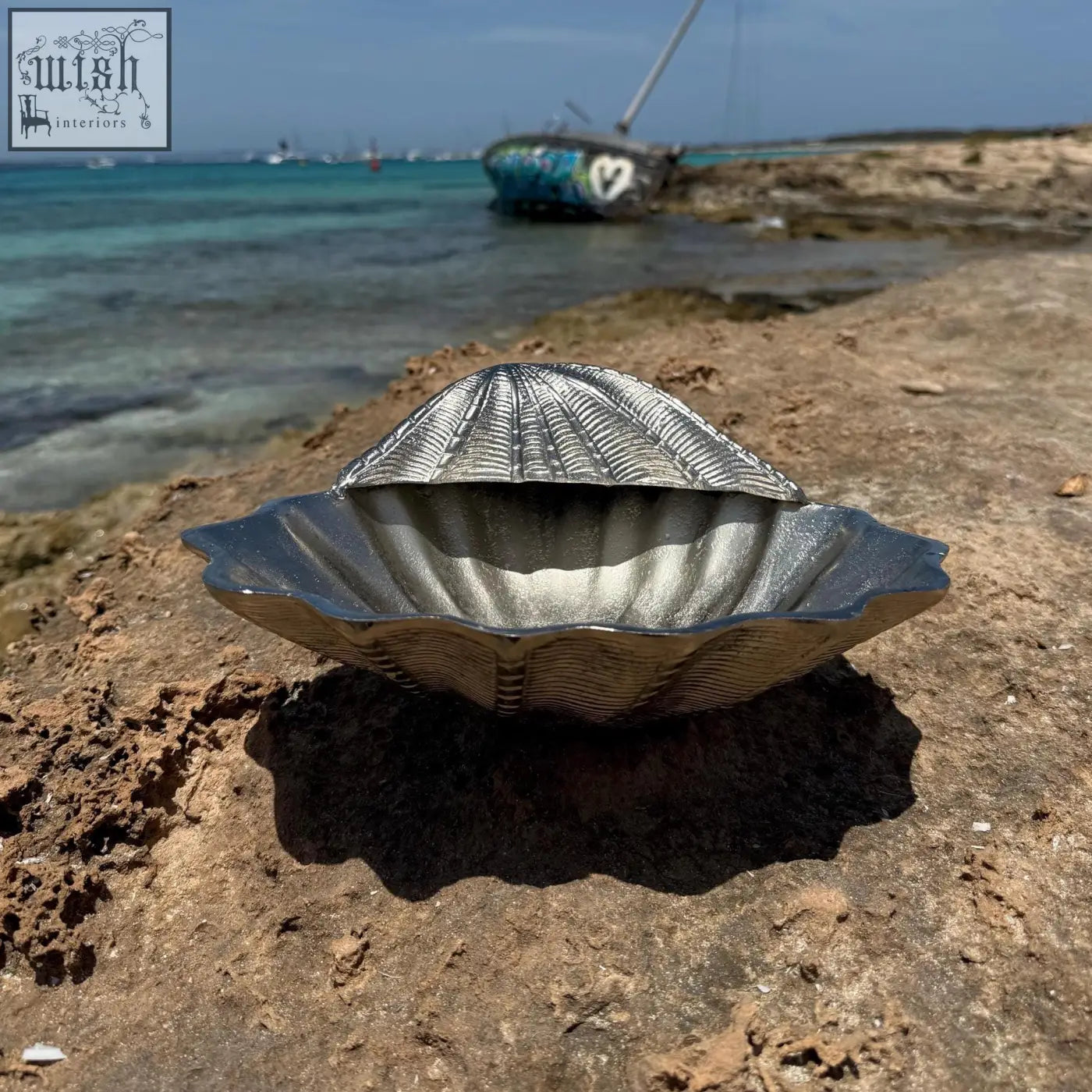 Silver metallic clamshell solid champagne ice bucket with ridged texture and scalloped edges for wine cooling