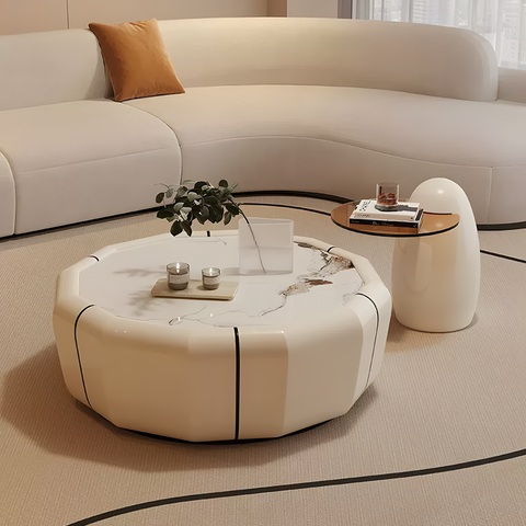 Cream-colored clara round coffee table set with white marble top black veining and geometric segmented sides