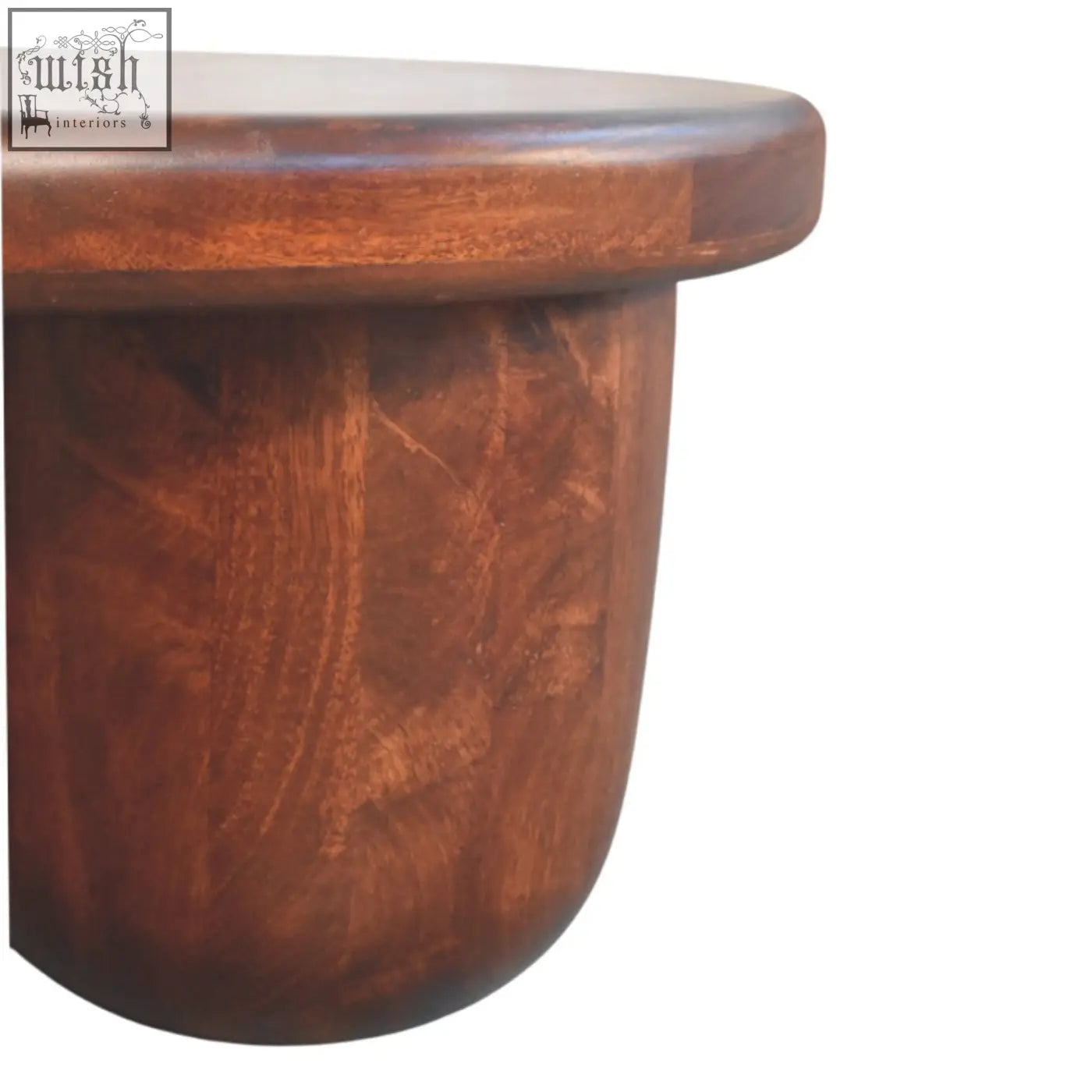 Clara sculpted coffee table in solid mango wood with rich warm tones and smooth rounded edges showing natural grain