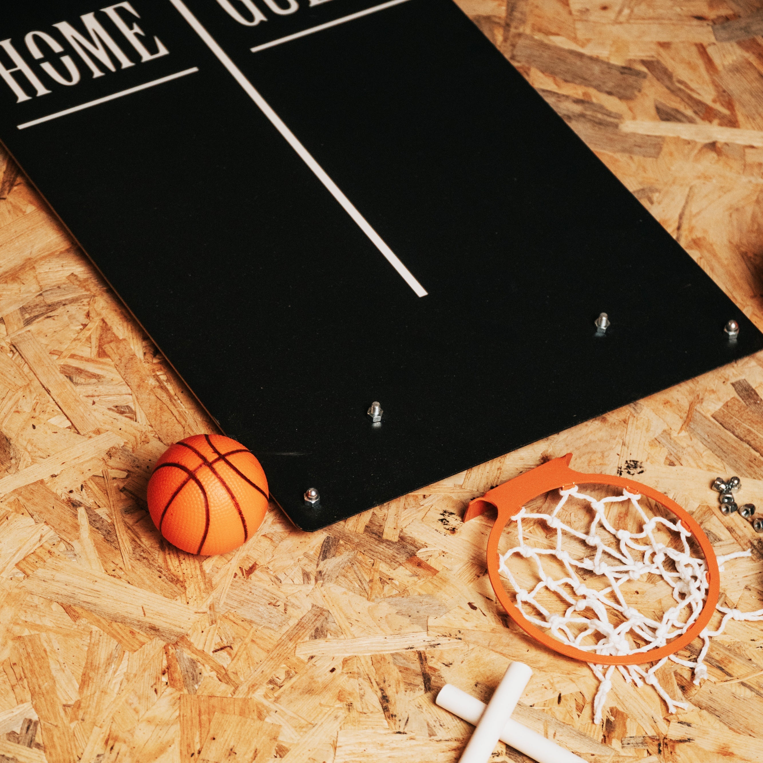 Black classic basketball wall game board with white lettering and orange ball near target area for indoor fun wall game