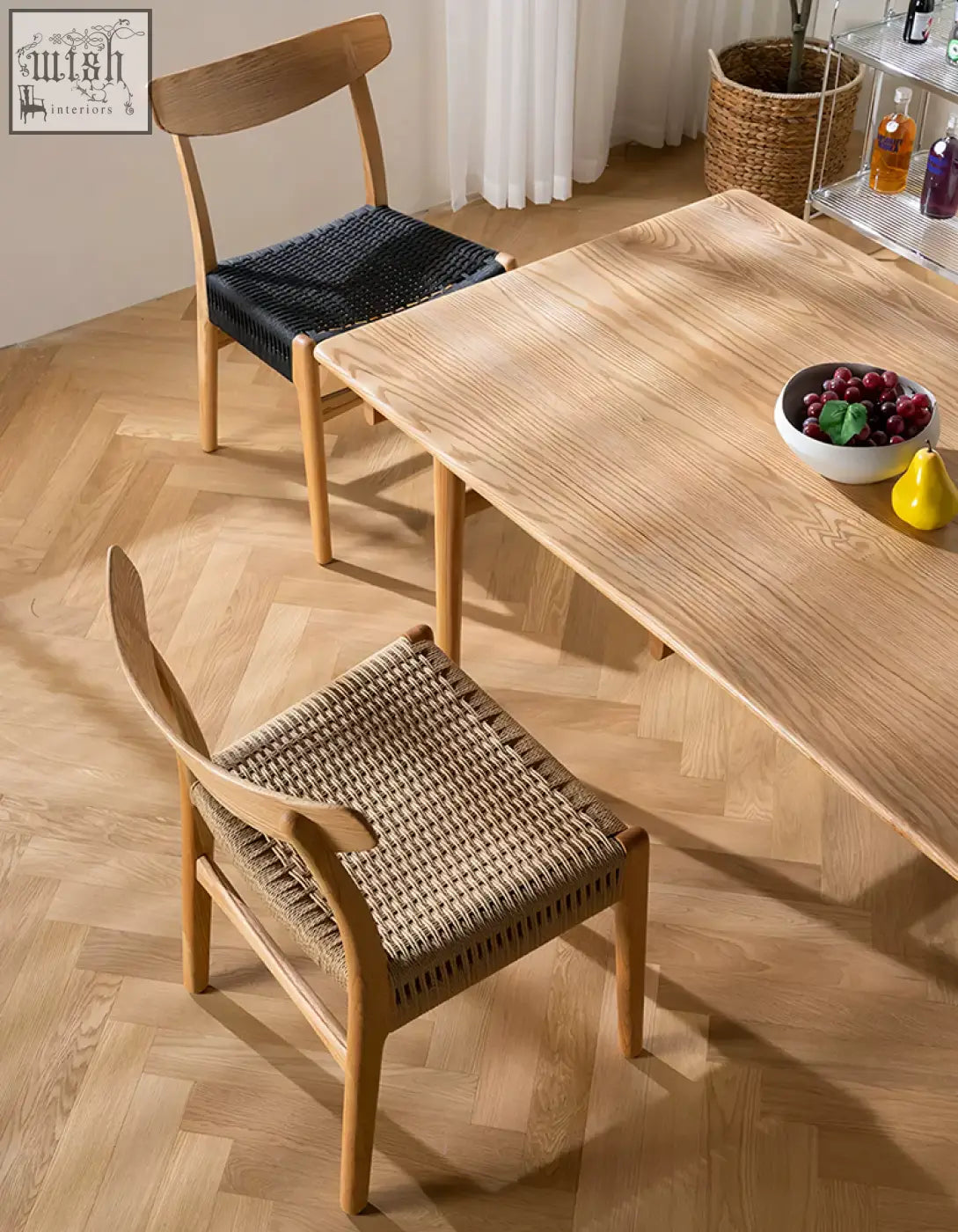 Light oak ch01 rattan dining chair with a light wood dining table featuring smooth natural grain and rounded edges