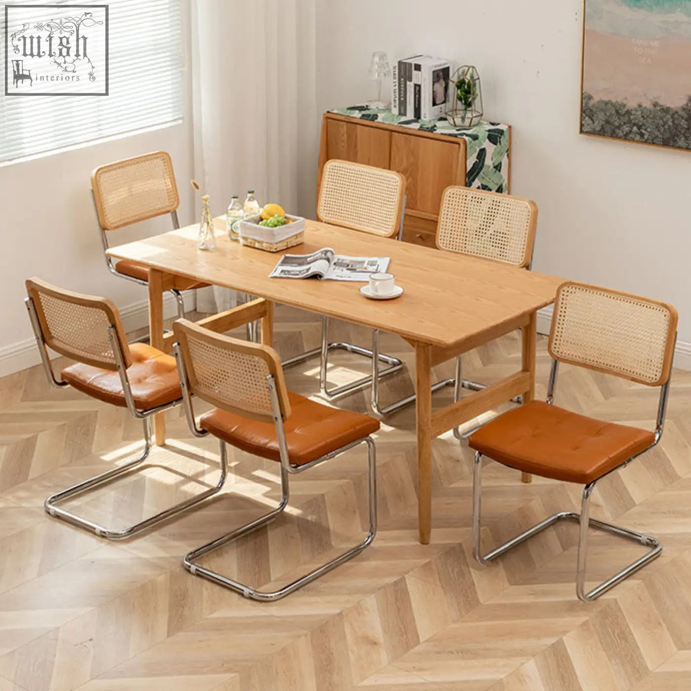 Light wood classic keaton rattan dining table with four cane-backed rattan dining chairs with leather seats and chrome legs