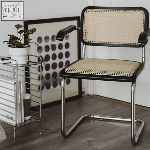 Classic keaton rattan dining chair with black-framed cane seat and sleek chrome tubular base with armrests