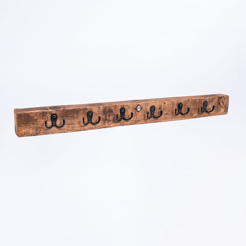 Rustic wooden wall-mounted coat rack with five black metal hooks in the classic key bum collection