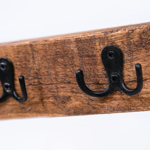Rustic wooden coat rack with black metal hooks in classic key bum rustic chic coat hanger design