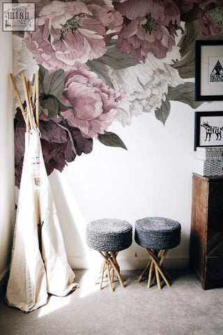 Classic peonies removable wallpaper with floral peony design displayed above two gray woven stools with wooden legs in living space
