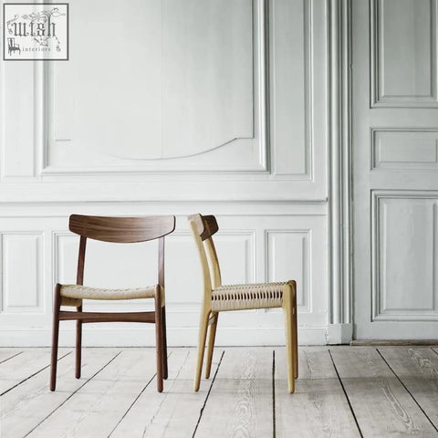Two minimalist ch01 rattan dining chairs with woven seats in dark oak and light natural wood tones