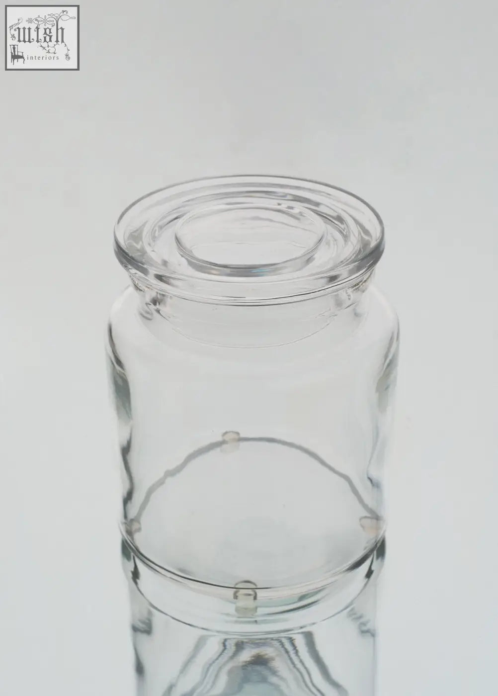 Clear storage jar set featuring a large clear glass jar with matching lid and subtle embossed design near the base