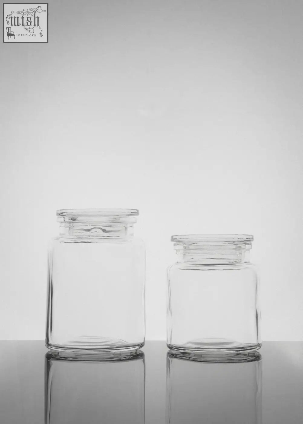 Two clear glass storage jars with matching lids in a storage jar set featuring a large jar for versatile use