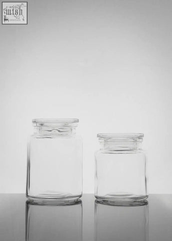 Two clear glass storage jars with matching lids in a storage jar set featuring a large jar for versatile use
