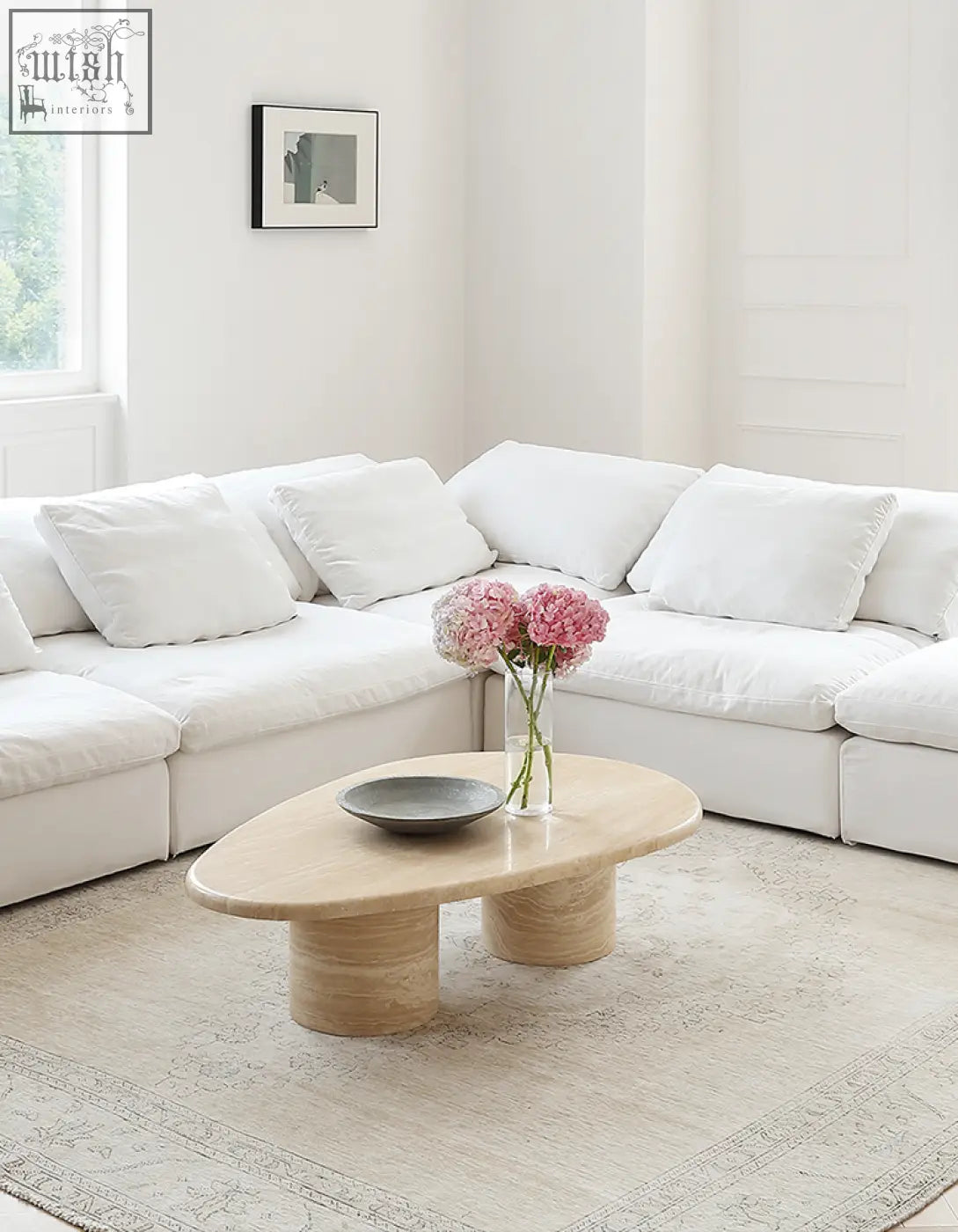 Light beige marble coffee table with smooth curves and an oval top supported by two cylindrical bases
