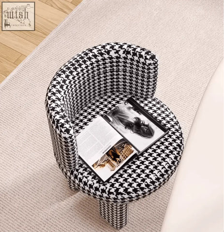 A sleek cloud dressing stool with rounded shape upholstered in bold black and white houndstooth pattern