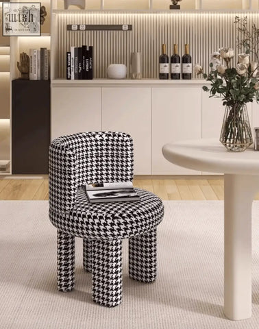 A stylish black and white houndstooth cloud dressing stool with rounded cushioned seat and wooden legs